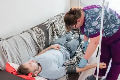 Фельдшер измеряет давление мужчине
